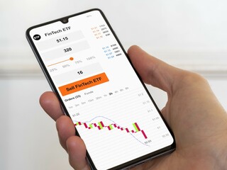 Stock exchange fin tech etf bear market chart, stock market data on smartphone. Business analysis of an FinTech ETF falls financial technology