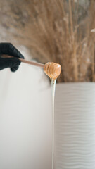 Liquid yellow sugar paste or wax for depilation on a wooden spoon for honey close-up