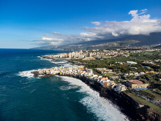 Fototapeta premium Aerial view on black lava rocks and Atlantic ocean in small village Punta Brava near Puerto de la Cruz, Tenerife, Canary islands