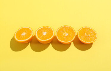 Fresh cut oranges on yellow background
