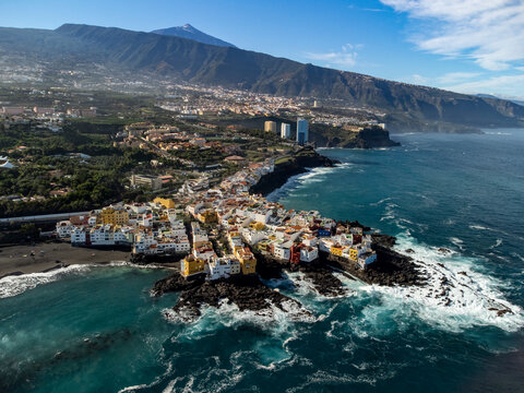 Aerial view on colorful houses , top of mount Teide and black lava rocks in small village Punta Brava near Puerto de la Cruz, Tenerife, Canary islands