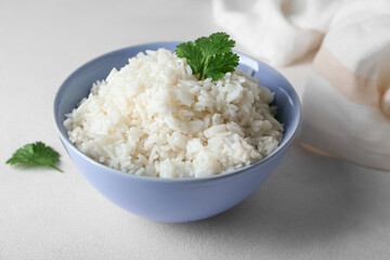 Bowl with tasty boiled rice on light background, closeup