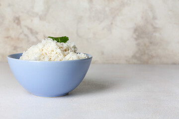 Bowl with tasty boiled rice on light background, closeup