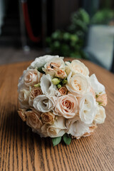 Wedding bouquet of fresh flowers, a pair of gold rings close-up. Wedding details