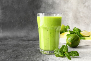 Glass of healthy green juice on grunge background