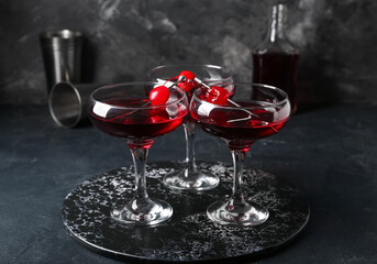 Glasses of tasty Manhattan cocktail on black background