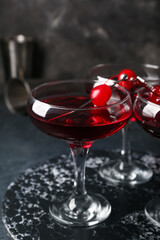 Glasses of tasty Manhattan cocktail on black background