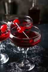 Glasses of tasty Manhattan cocktail on black background
