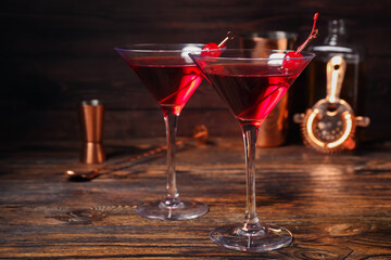 Glasses of tasty Manhattan cocktail on dark wooden background