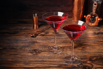 Glasses of tasty Manhattan cocktail on dark wooden background