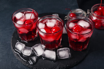Glasses of tasty Manhattan cocktail on black background