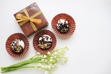 spring greeting card layout. a small bouquet of lilies of the valley and chocolates 