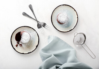 Plates with tasty lava cake fondant on white background