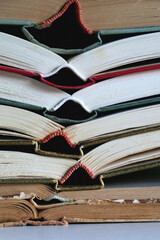 Naklejka premium Stack of open vintage hardcover book on the table. Selective focus.