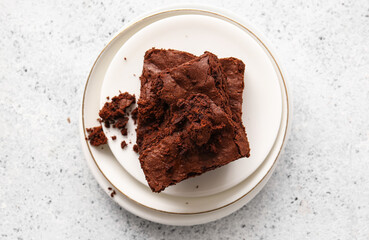 Plates with pieces of tasty chocolate brownie on white background