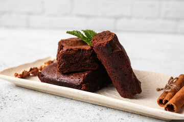 Plate with pieces of tasty chocolate brownie on table