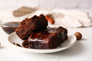 Plate with pieces of tasty chocolate brownie on table
