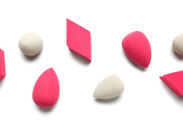 Different makeup sponges on light background