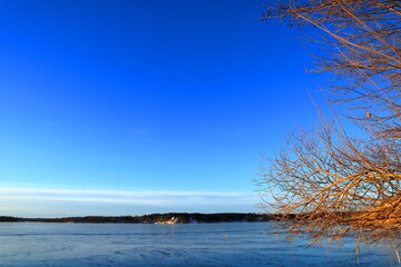 Sea landscape during the winter. Snow and ice covering the lake. With a horizon. Blue sky and nice weather. One calm day. Stockholm, Sweden.