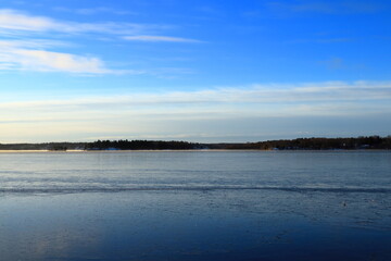 Sea landscape during the winter. Snow and ice covering the lake. With a horizon. Blue sky and nice weather. One calm day. Stockholm, Sweden.