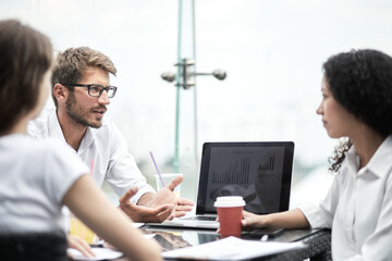 Fototapeta premium Smiling colleagues working together developing business strategy for their next project. Young casually dressed business people having discussion on sunny terrace. Modern job in comfortable conditions