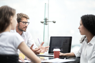 Smiling colleagues working together developing business strategy for their next project. Young casually dressed business people having discussion on sunny terrace. Modern job in comfortable conditions