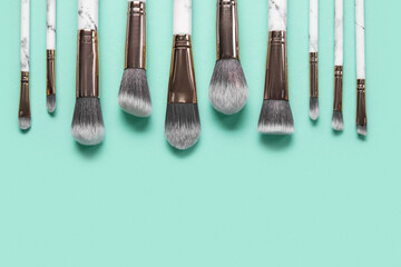 Set of makeup brushes on turquoise background