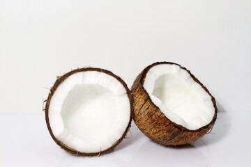Two halves of coconut on white