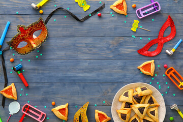 Frame made of party decor and Hamantaschen cookies with rattles for Purim holiday on color wooden background