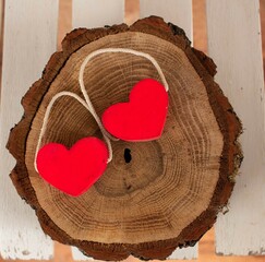 two wooden red hearts on a round circle slice piece of wood background