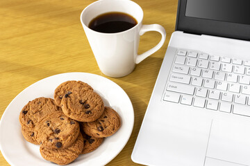 休憩時間にクッキーを食べ、ノートパソコンを使うイメージ