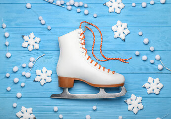Ice skate and snowflakes on color wooden background