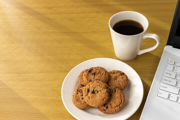 休憩時間にクッキーを食べ、ノートパソコンを使うイメージ