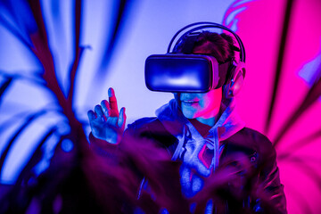 Woman interacting in virtual reality with VR glasses, enjoying the metaverse.