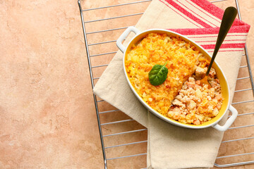 Baking dish with tasty English fish pie on beige background