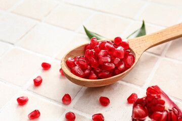 Ripe delicious pomegranate on light tile background