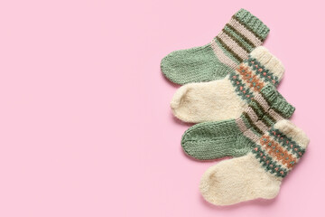 Warm knitted socks on pink background