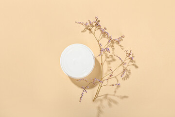 Jar with natural cosmetic cream on beige background