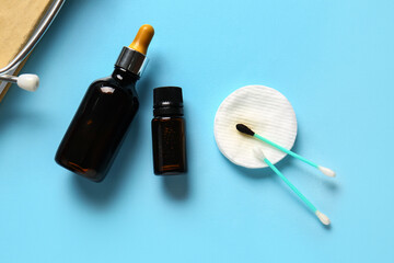 Obraz premium Bottles with iodine, cotton swab and pad on blue background