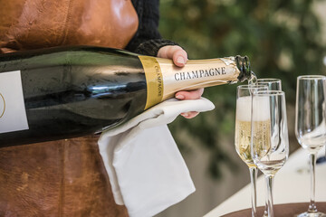 Serveuse versant du champagne dans des coupes pendant une réception
