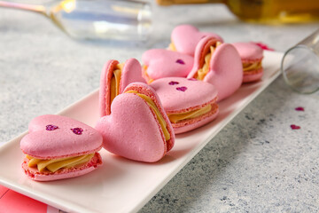 Plate with tasty heart-shaped macaroons on light background, closeup