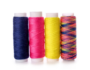 Different sewing thread spools on white background