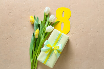 Beautiful tulip flowers and gift box for International Women's Day on beige background