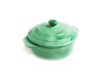 Green ceramic saucepan with a lid on a white background.