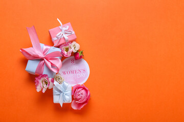 Composition with card for International Women's Day, flowers and gift boxes on color background