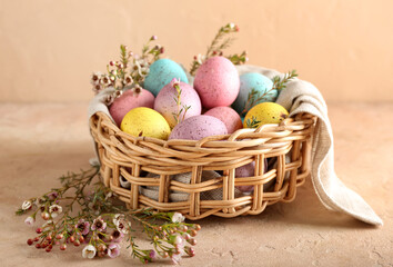 Fototapeta na wymiar Basket with beautiful Easter eggs and flowers on color background