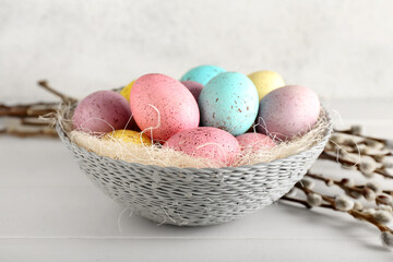 Bowl of beautiful Easter eggs on table, closeup
