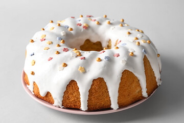 Plate with tasty Easter cake on light background