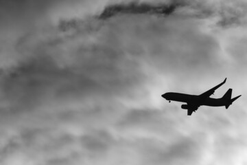 Airplane passing under a clouded sky