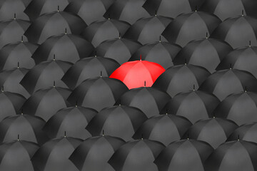 Sea of black umbrellas with one red umbrella in the center, symbolizing an idea, innovation,...